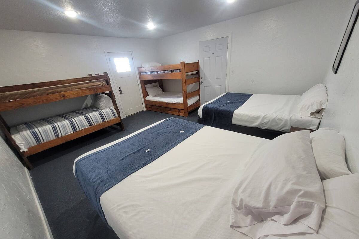 A room with bunk beds, a door, and a window.