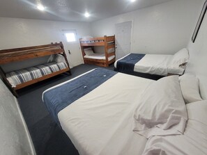 Una habitación con literas, una puerta y una ventana.
