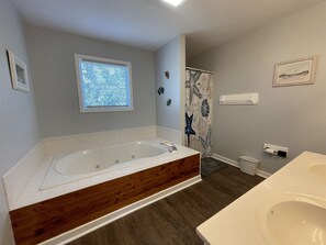 A bathroom with a bathtub, a shower, a toilet, and a sink.