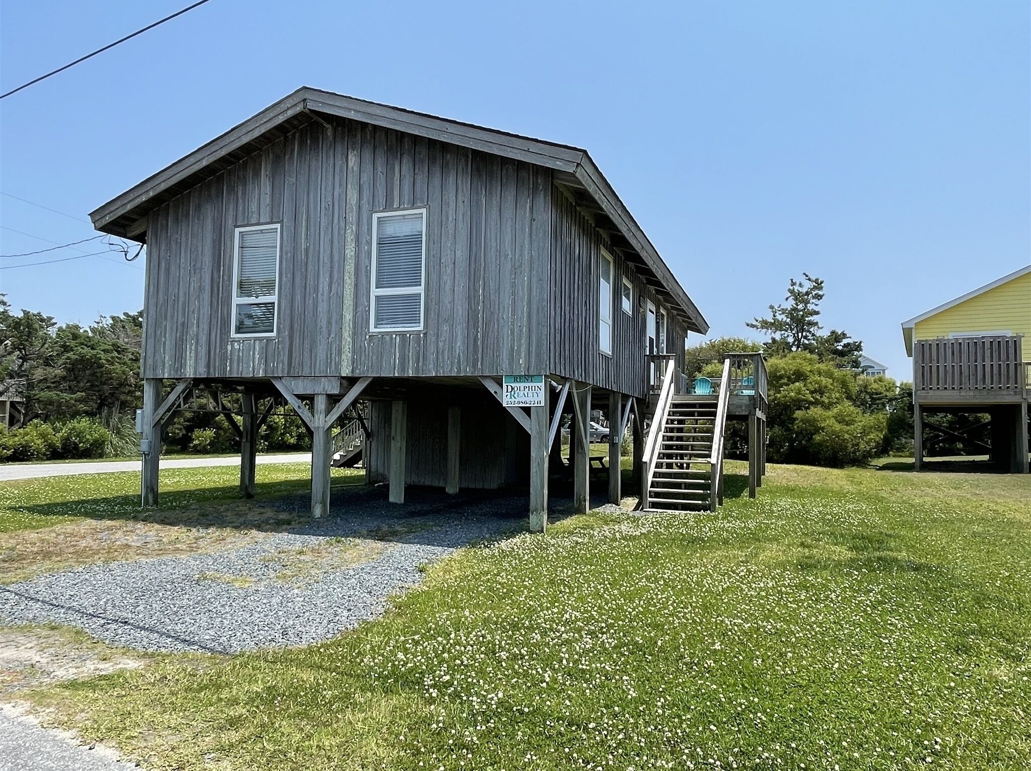 A wooden house with a porch and a staircase leading up to it.