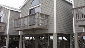A building with a balcony, a staircase, and a car parked in front. - 4 Carolina Lady Studio Bedroom Condo by RedAwning (Hatteras)