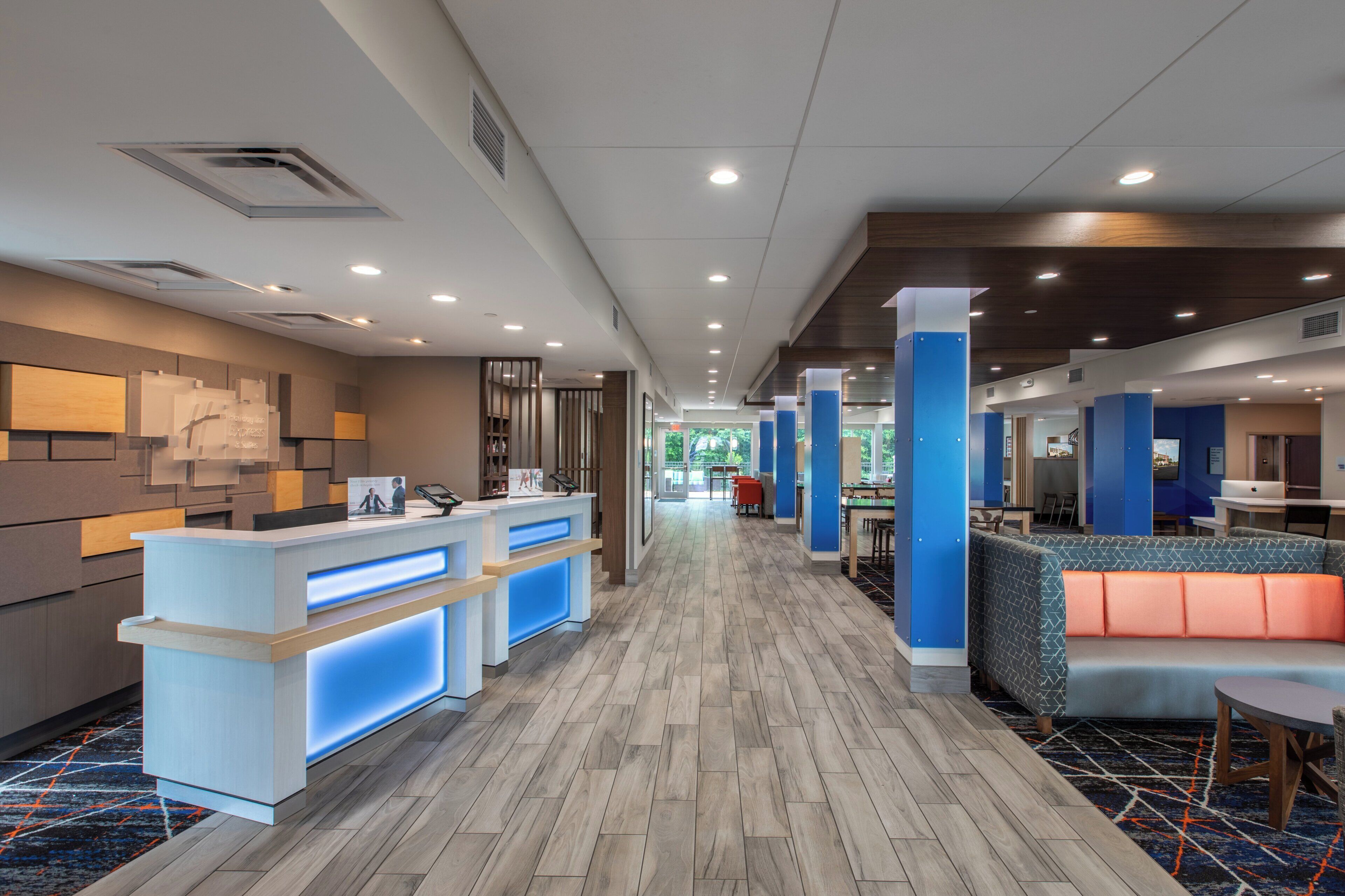 A hotel lobby with a reception desk, seating area, and a view of the outdoors.