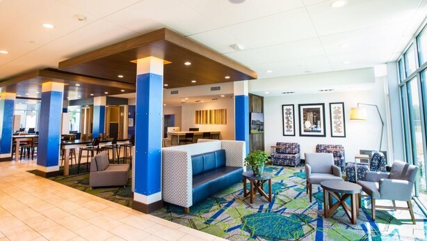 A hotel lobby with a seating area, a bar, and a reception desk. - Holiday Inn Express & Suites Greenville S- Piedmont by IHG (Piedmont)