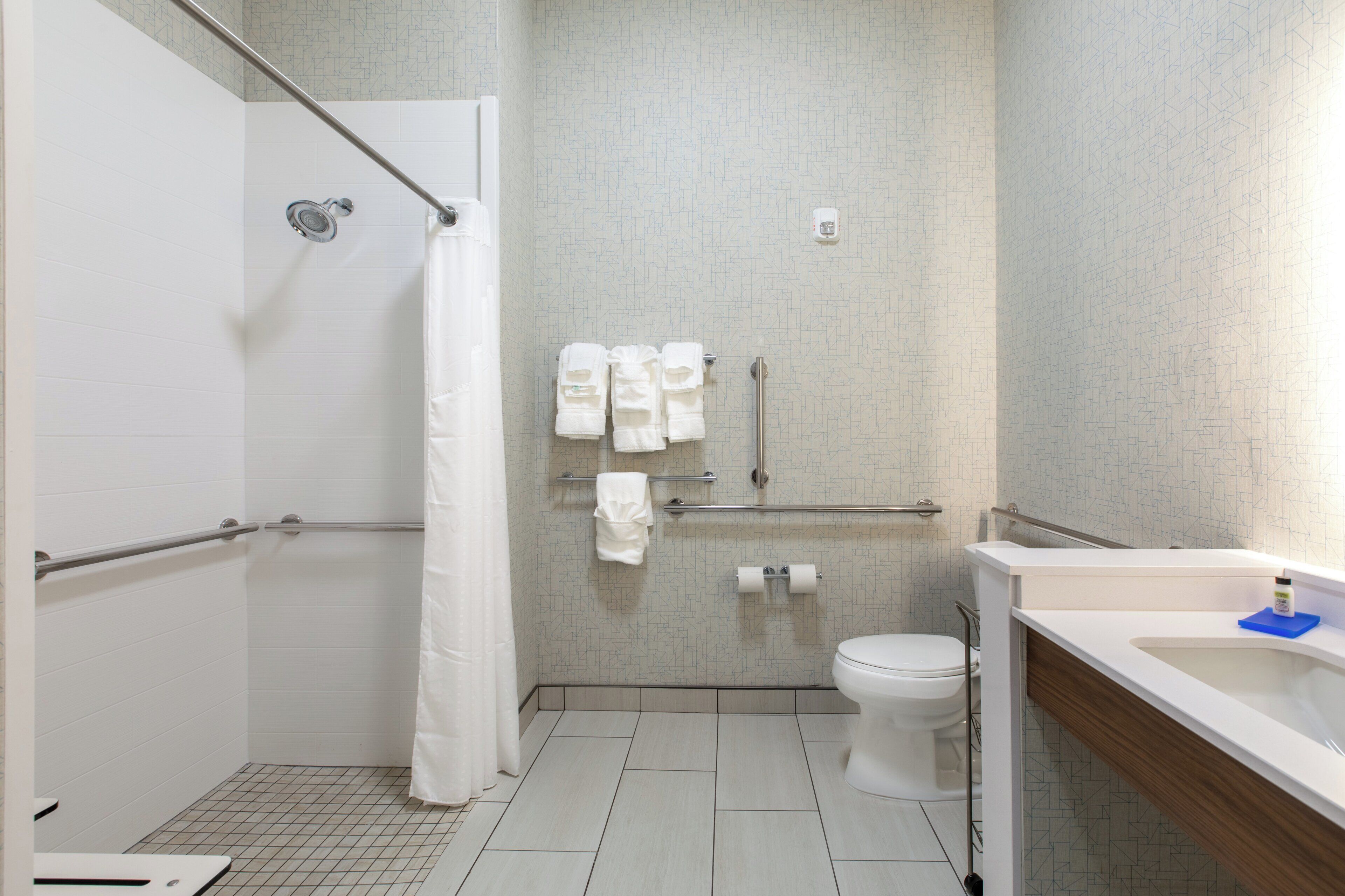 Un baño de hotel estándar con ducha, inodoro y lavamanos.