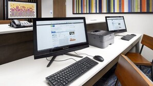 A modern office desk with two monitors, a keyboard, and a mouse. There is a printer and a telephone on the desk. - Holiday Inn Express & Suites Greenville S- Piedmont by IHG (Piedmont)