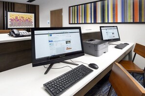 Un escritorio moderno con dos monitores, un teclado y un ratón. Hay una impresora y un teléfono sobre el escritorio.