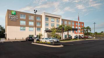 A Holiday Inn Express & Suites hotel with a parking lot and several cars parked in front.