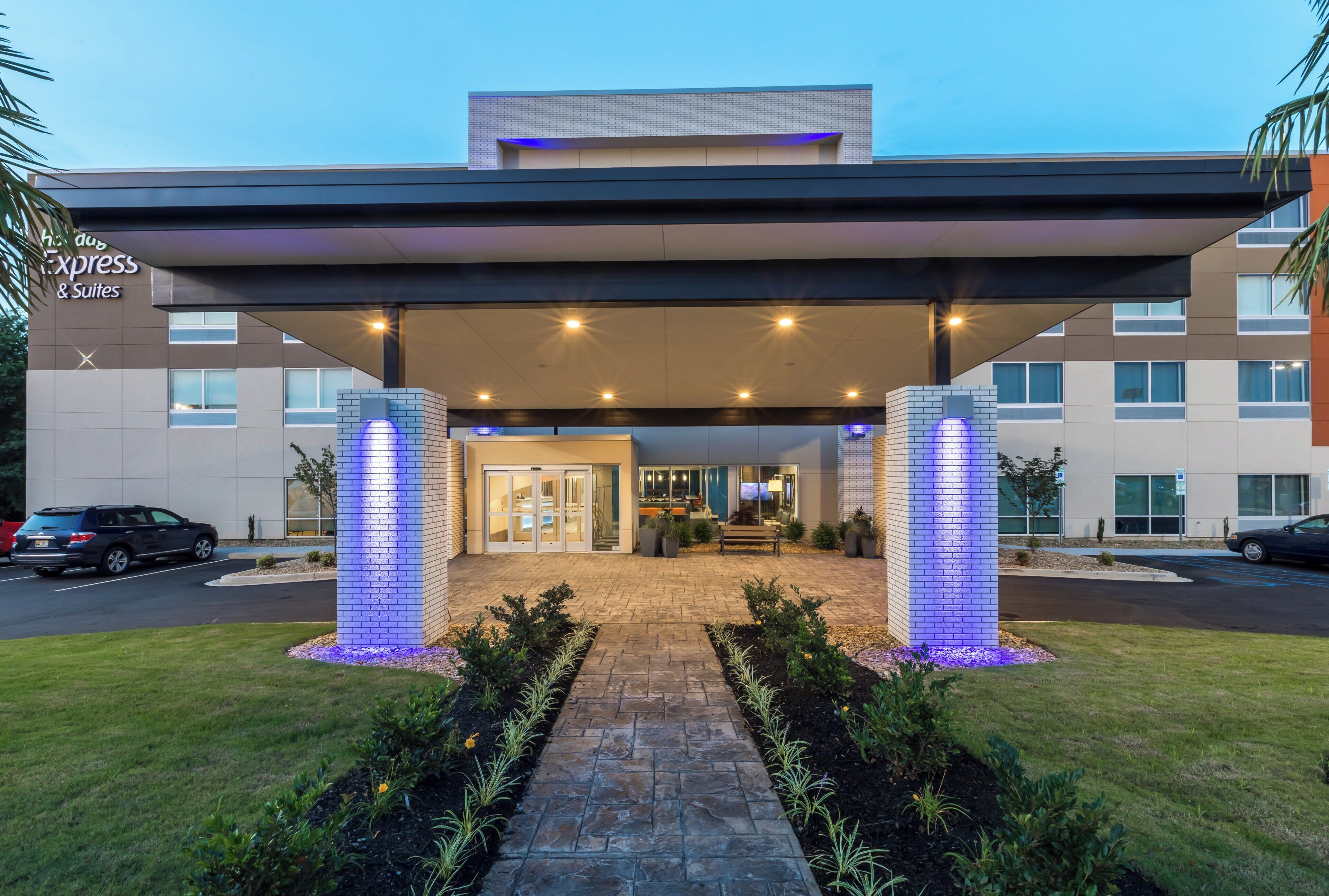 Ein Hotel mit überdachtem Eingangsbereich, einer Rezeption und einem Parkplatz.