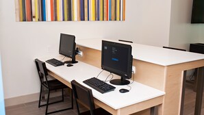A workspace with two computer monitors, a keyboard, and a mouse on a white desk.