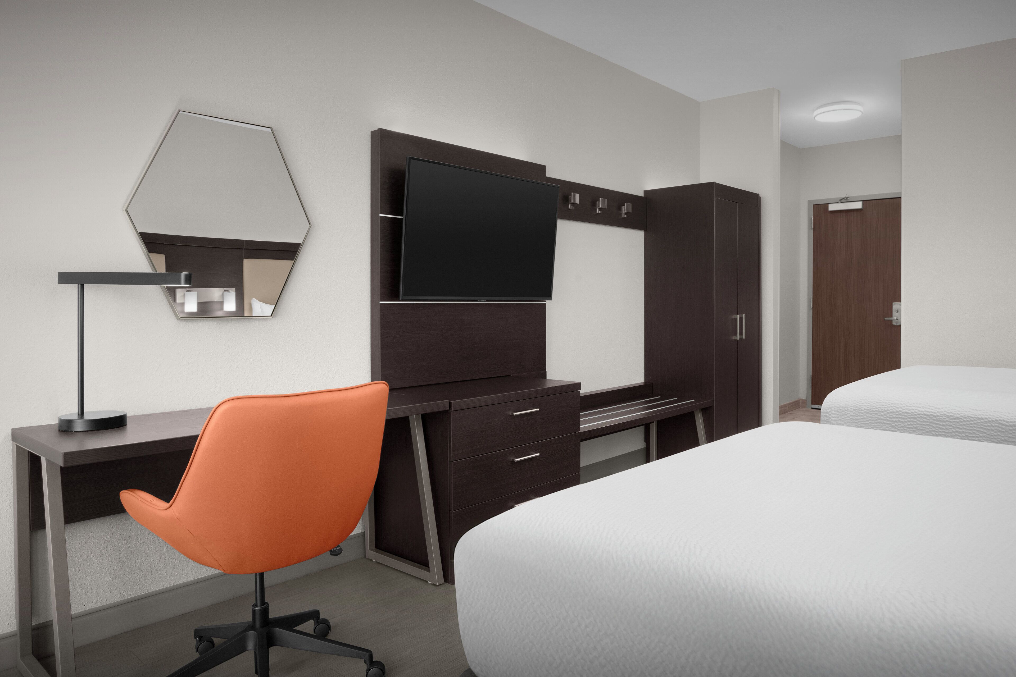 أغطية فراش متميزة وخزنة داخل الغرفة ومكتب ومساحة عمل للكمبيوتر المحمول