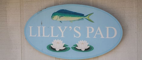 A sign with a fish and lotus flowers, labeled "LILLY'S PAD".