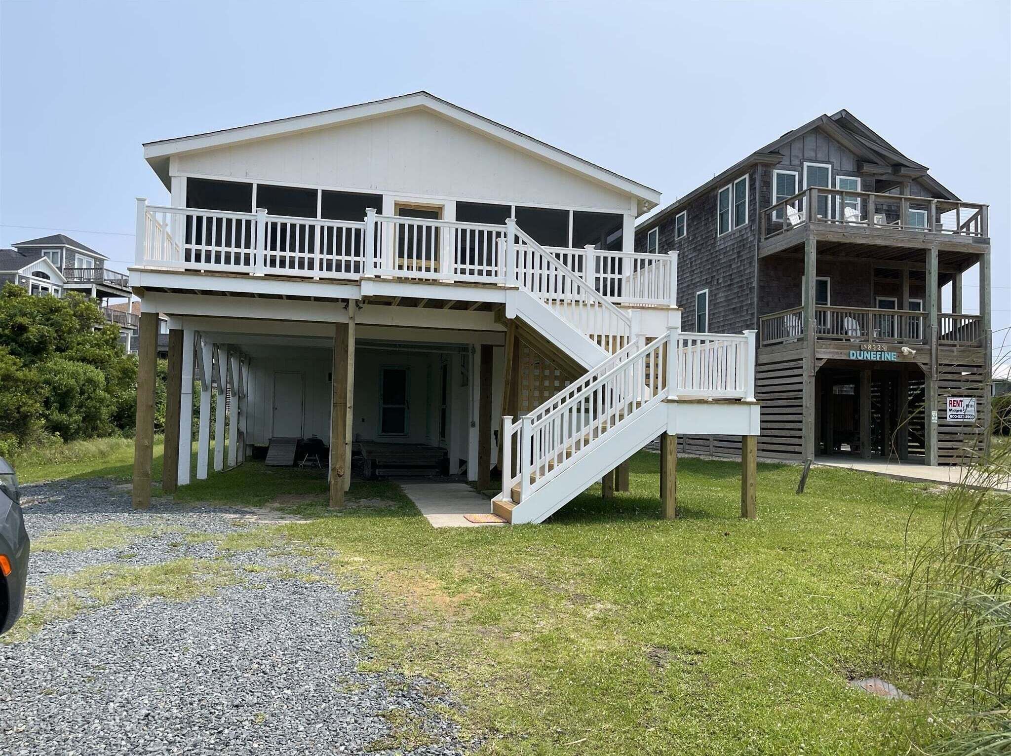 A two-story house with a covered porch and a staircase leading to the upper level.