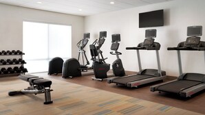 A gym with treadmills, elliptical machines, and a bench. - Holiday Inn Express & Suites-Cincinnati South - Wilder by IHG (Newport)