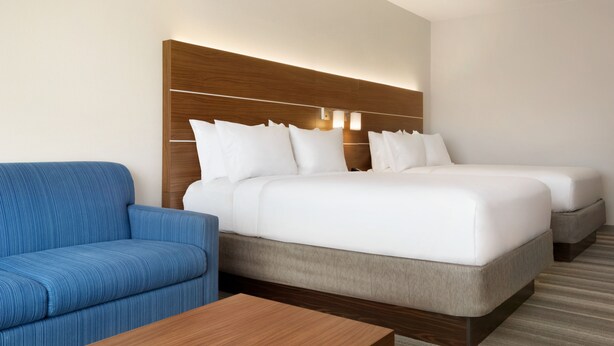 A hotel room with a large bed, a sofa, and a wooden headboard. - Holiday Inn Express & Suites-Cincinnati South - Wilder by IHG (Newport)