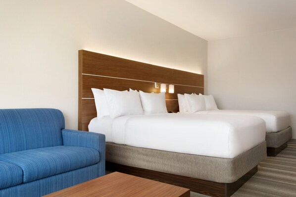 Une chambre d’hôtel avec un grand lit, un canapé et une tête de lit en bois.