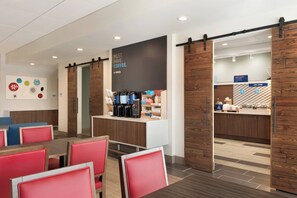 A modern cafe with red chairs, a coffee bar, and a sign that says 'MUST. HAVE. COFFEE.' - Holiday Inn Express & Suites-Cincinnati South - Wilder by IHG (Newport)