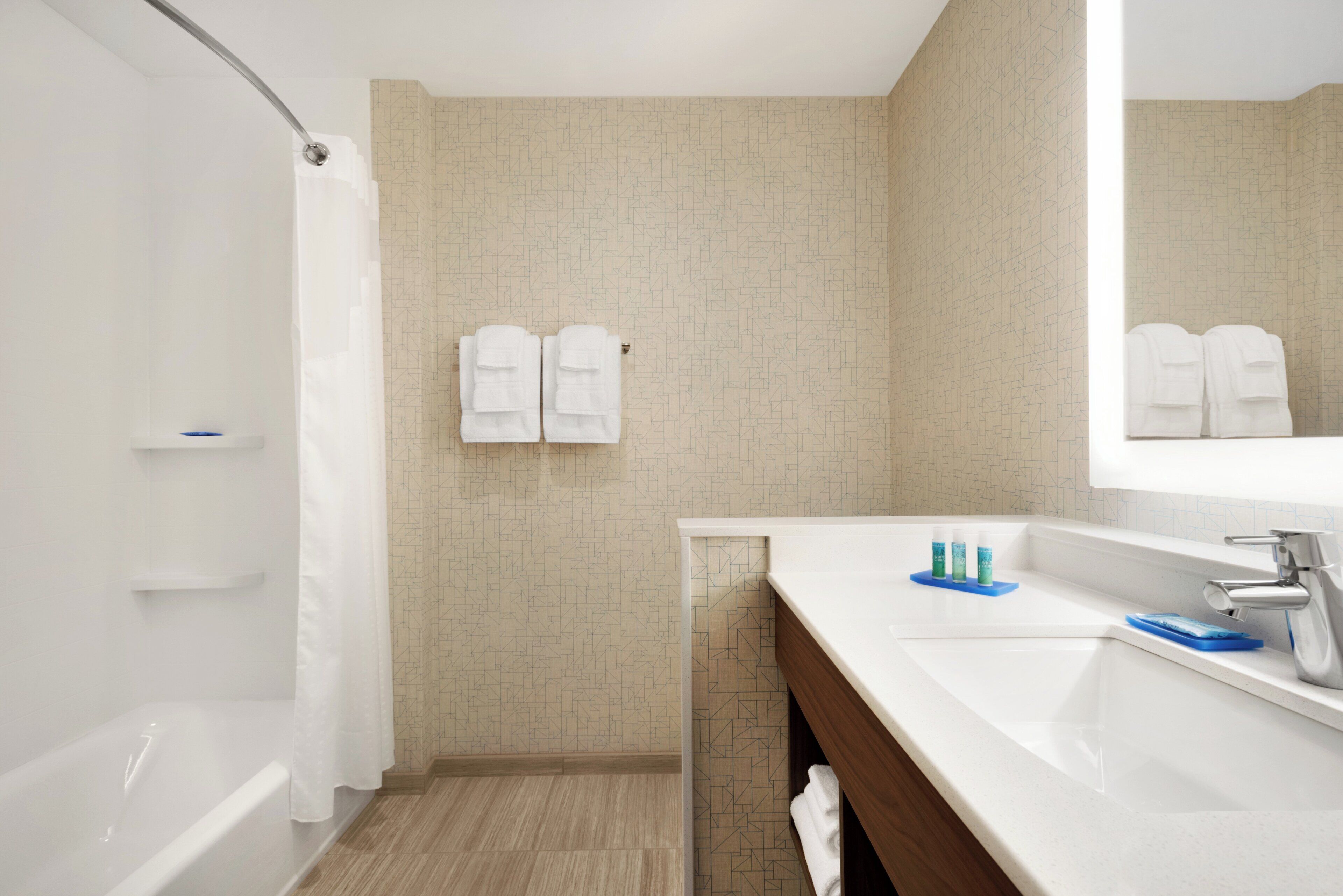 A bathroom with a shower, a sink, and a mirror.
