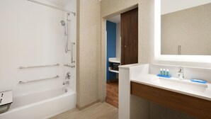 A modern bathroom with a bathtub, shower, and vanity with a mirror. - Holiday Inn Express & Suites-Cincinnati South - Wilder by IHG (Newport)
