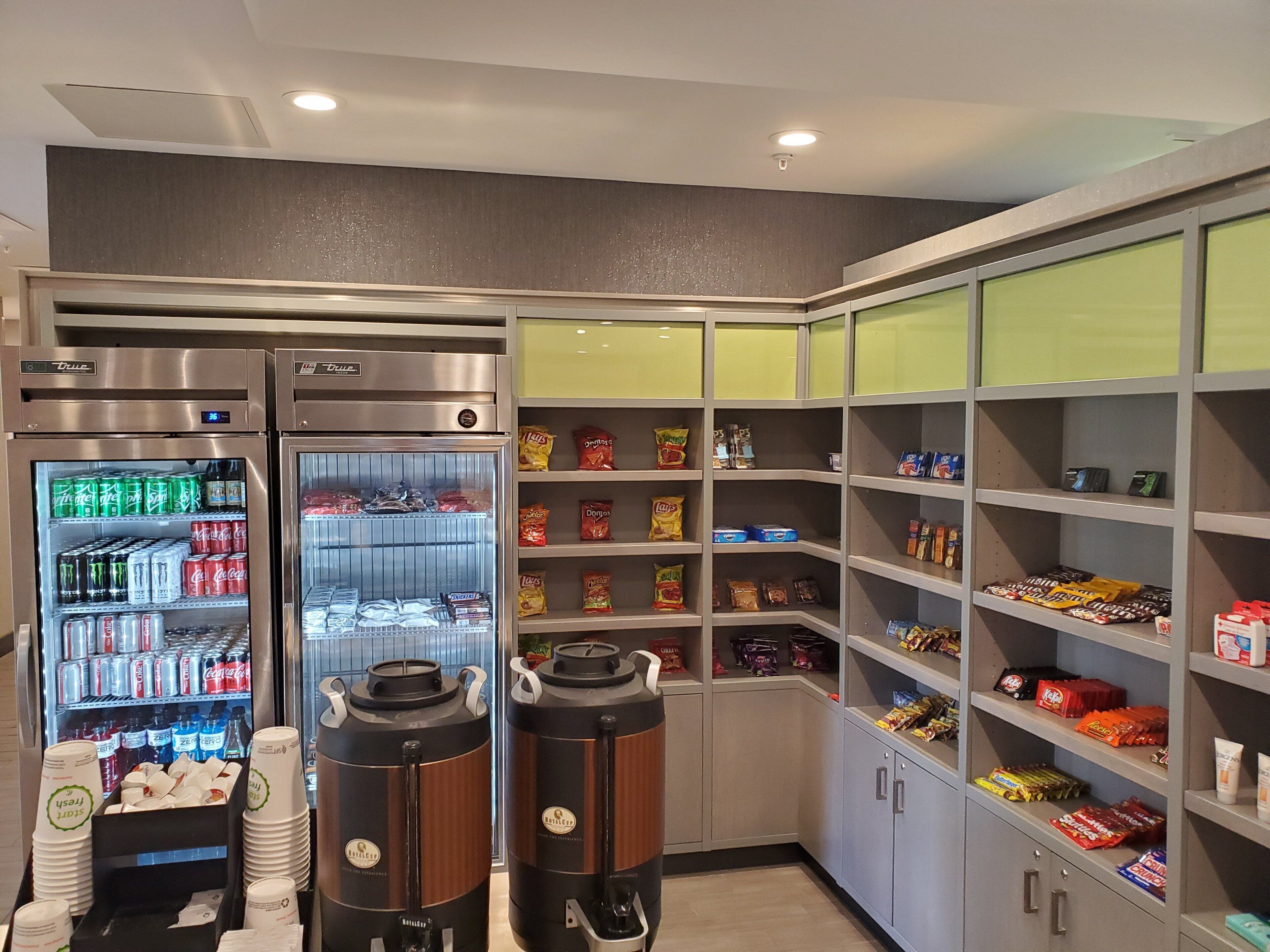 Una estación de autoservicio para bebidas con refrigerios fríos y una máquina de café.