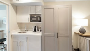 A modern kitchen with white cabinetry, a built-in microwave, a coffee maker, and a sink. - Holiday Inn & Suites Decatur-Forsyth by IHG (Decatur)