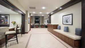 Vestíbulo de hotel con recepción, zona de estar y comedor.