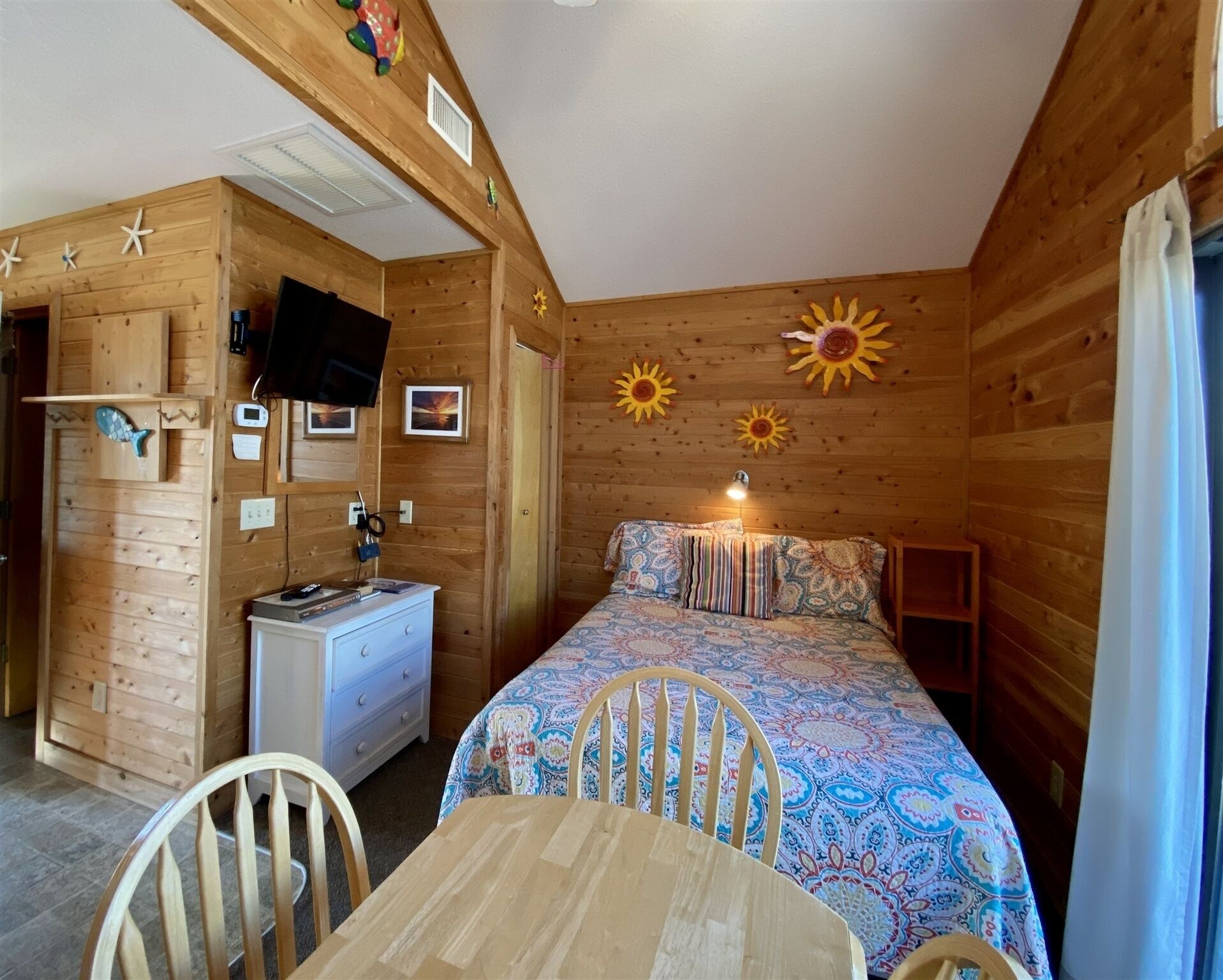 Une chambre dans un chalet en bois, avec un lit, un bureau et une chaise.