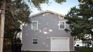 A two-story house with a garage, a small window, and a mailbox.