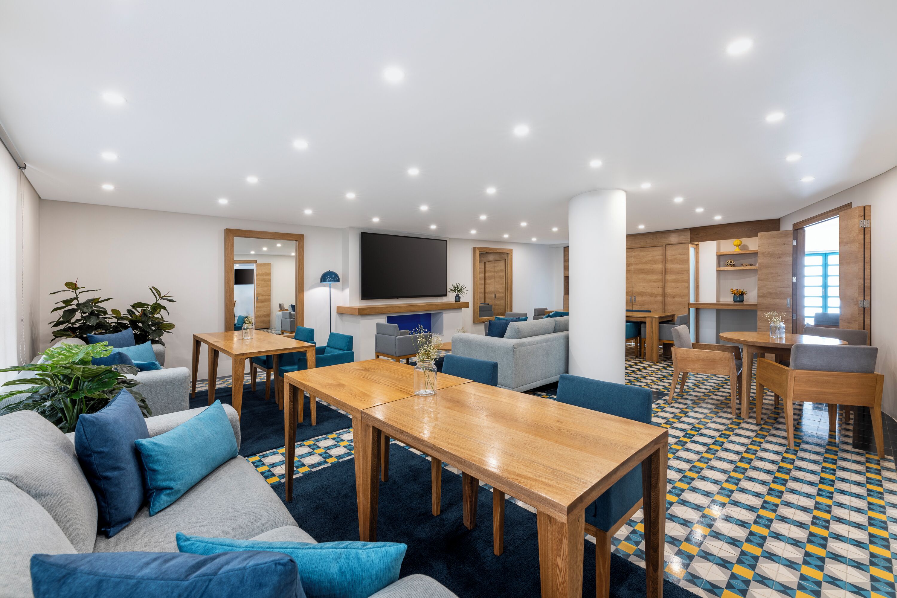 A modern living area with a large flat-screen TV, comfortable seating, and a dining area.