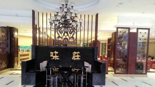 A lobby with a black reception desk, a chandelier, and a modern interior design. - Greentree Inn Suzhou Shengze Business Hotel (Suzhou)