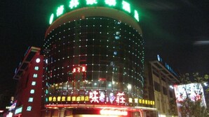 A building with a curved facade, illuminated by numerous lights. - Greentree Inn Suzhou Shengze Business Hotel (Suzhou)