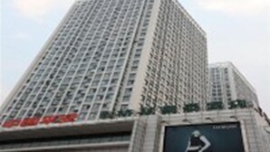 A tall building with a grid of windows and a sign that reads "HOTEL". - Greentree Inn Qinghuangdao Sun City Hotel (Qinhuangdao)