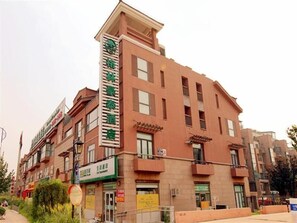 A multi-story hotel with a prominent green sign on the facade. - GreenTree Inn Beijing Changping District Beiqijia Future Science & Technology City Hotel (Beijing)