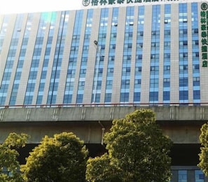 A modern building with a series of vertical windows and a concrete overpass in the foreground. - Greentree Inn Suzhou Station Hotel (Suzhou)