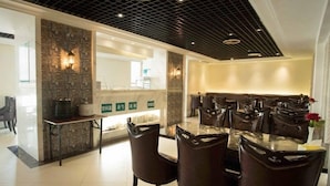A modern dining area with a black grid ceiling, stone wall accents, and a central island with a sink. - Greentree Inn Suzhou Station Hotel (Suzhou)