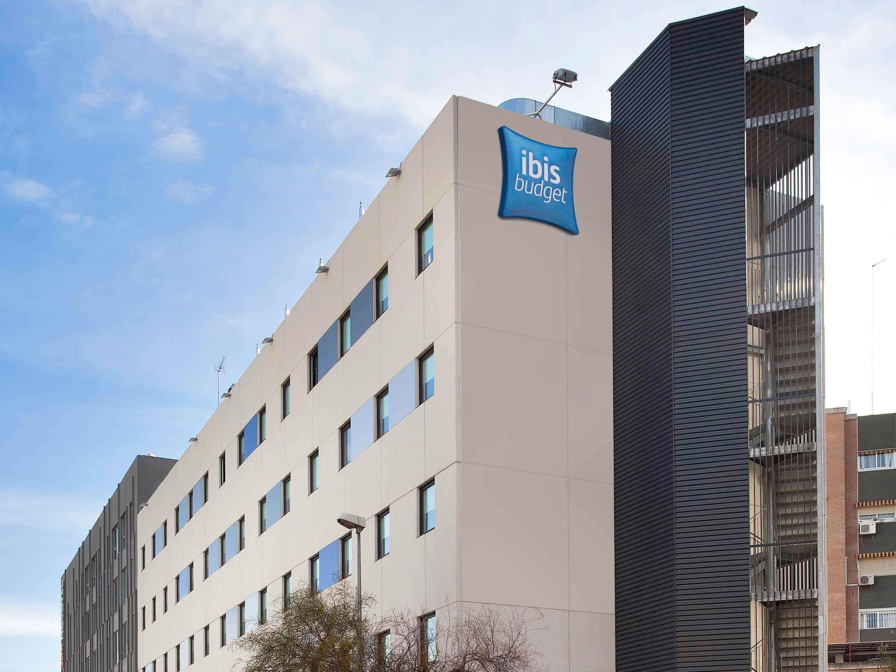 A modern building with a sign for 'ibis budget' indicating it is a budget hotel.