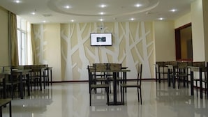 A spacious dining area with multiple tables and chairs, a modern ceiling design, and a wall-mounted television. - GreenTree Inn Tianjin Wuqing Jingbin Industrial Park Chengwang Road Express Hotel (Tianjin)