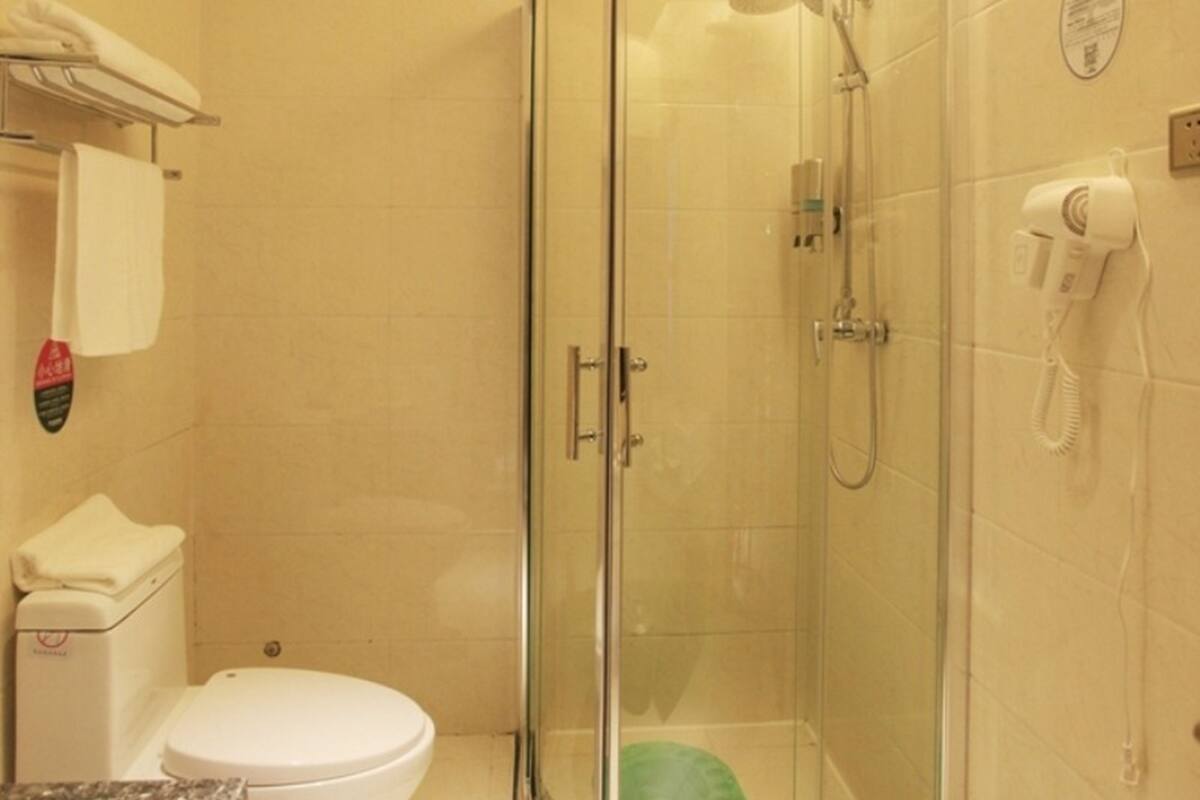 Un box de ducha con paredes de vidrio, equipado con ducha de mano y rociador manual.