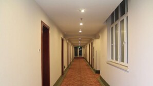 Un pasillo largo y estrecho en un hotel, con alfombra en el suelo y puertas a ambos lados.