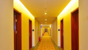 A hotel hallway with carpeted floors, wooden doors, and overhead lighting. - GreenTree Inn ChangZhou East DongFang Road HengNai Logistics Park Express Hotel (Changzhou)