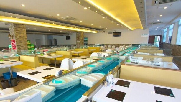 A modern restaurant with a long counter, individual seating, and a central water feature. - GreenTree Inn ChangZhou East DongFang Road HengNai Logistics Park Express Hotel (Changzhou)
