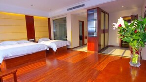A hotel room with two beds, wooden flooring, a glass partition, and a vase with flowers. - GreenTree Inn ChangZhou East DongFang Road HengNai Logistics Park Express Hotel (Changzhou)