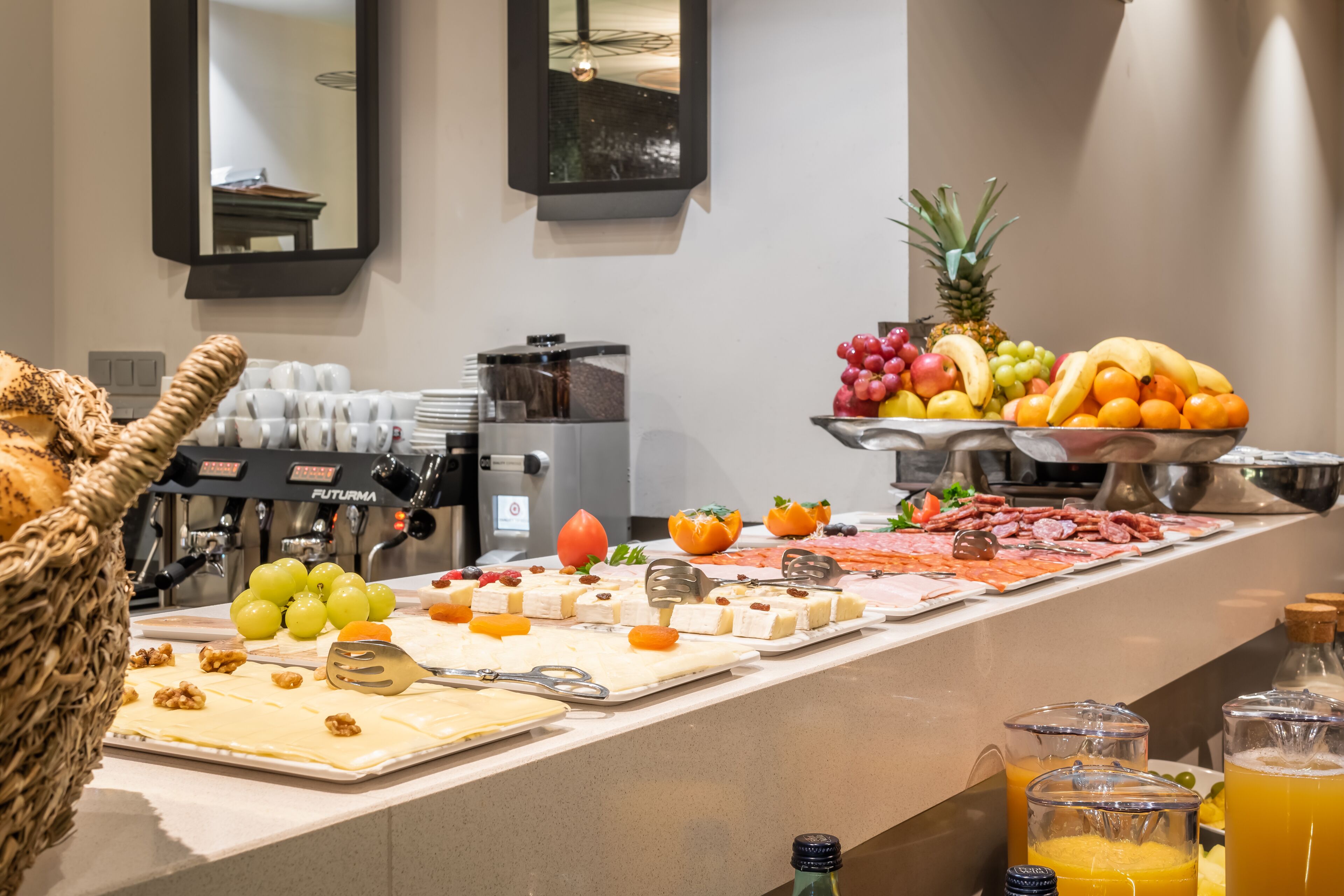 A buffet with various food items, including fruits, cheeses, and meats.