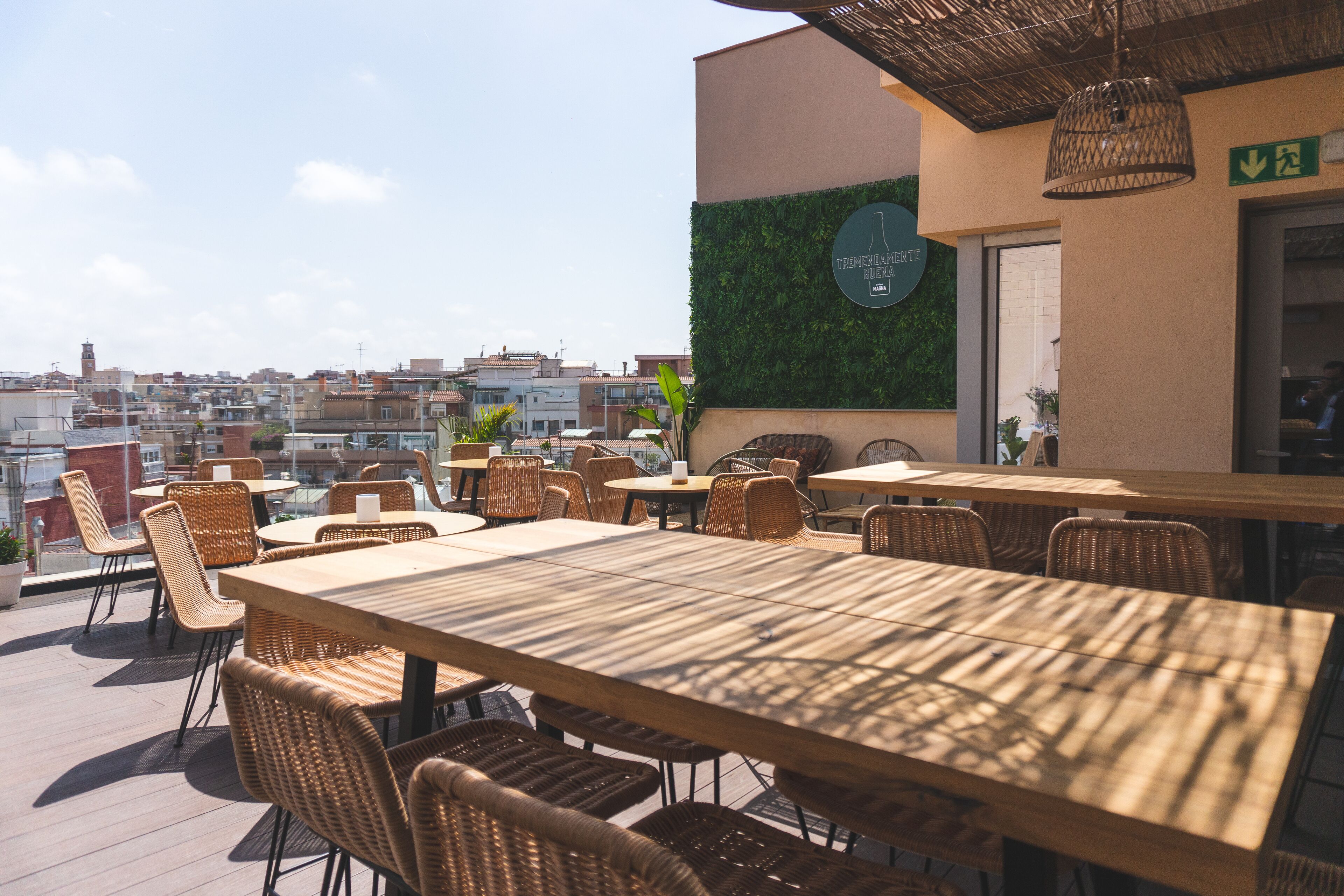 An outdoor seating area with wicker furniture and a view of the cityscape.