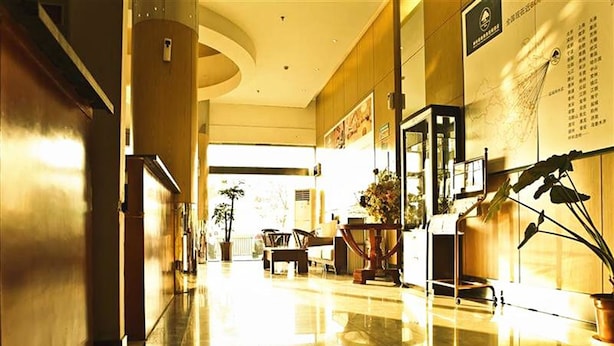 A spacious lobby with a curved ceiling, a reception desk, and a seating area with chairs and a table. - GreenTree Inn Yancheng Xiangshui Bus Station Express Hotel (Yancheng)