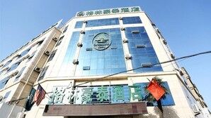 A hotel with a modern glass facade and a prominent sign at the top. - GreenTree Inn Fuyang Taihe County South Xiyang Road Hotel (Fuyang)