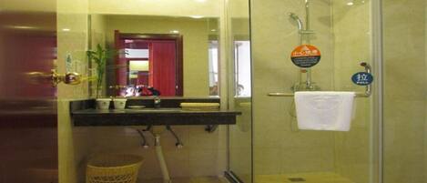 A bathroom with a glass-enclosed shower, a sink with a mirror above it, and a towel rack.