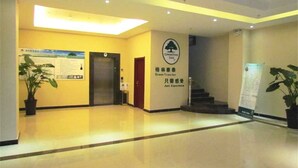 A hotel lobby with a reception desk, a staircase, and a sign for Green Tree Inn. - GreenTree Inn Fuyang Taihe County South Xiyang Road Hotel (Fuyang)