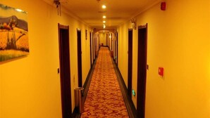 A hotel hallway with a carpeted floor, doors on both sides, and a corridor extending into the distance. - GreenTree Inn Fuyang Taihe County South Xiyang Road Hotel (Fuyang)