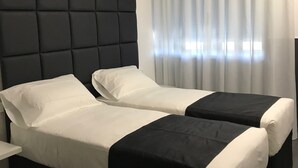 A hotel room with two beds, a dark headboard, and a large window with sheer curtains. - Hotel Pex (Rubano)