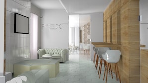 A modern interior with a sofa, chairs, a wooden wall, and a hexagonal pattern wall. - Hotel Pex (Rubano)